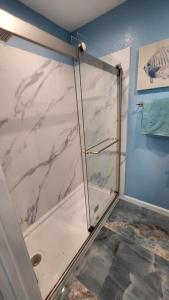 a bathroom with a shower with a glass door at Acapulco - Upstairs Beachview Beauty 50 steps to a private beach! BYOT in Galveston +12 photos