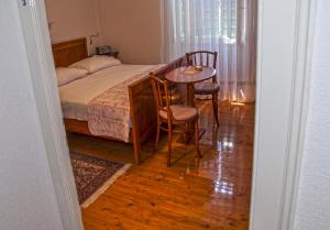 a bedroom with a bed and a table and chairs at Marina Rooms in Komiža +10 photos