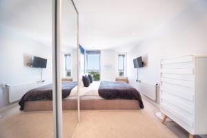 1 Schlafzimmer mit 2 Betten und einem Spiegel in der Unterkunft Top Floor Apt - 2 Bed/2 Bath + Private Balcony in London