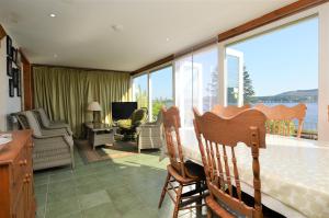 een woonkamer met een tafel en stoelen en een balkon bij Ardmun House in Dunoon