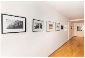 a hallway with four framed photographs on a wall at Rooms in Luxury Apartment, Central Vienna near Hauptbahnhof in Vienna