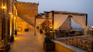 un patio al aire libre con toldos y mesas en un edificio en zerzevan hotel, en Mardin