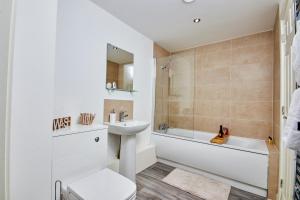 a bathroom with a sink and a toilet and a tub at Stylish 2 Bed Apartment with Free parking, close to City Centre by Hass Haus in Manchester
