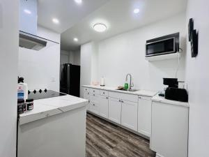 a white kitchen with white cabinets and a microwave at Downtown charm with space to spare in Montréal