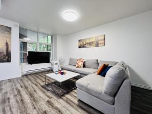 uma sala de estar com um sofá e uma televisão em Downtown charm with space to spare em Montreal
