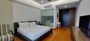 a bedroom with a white bed and a fireplace at Jazz Service Suite Tanjung Tokong in Bagan Jermal