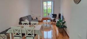a living room with a couch and a table and chairs at Erdizka, céntrico apartamento turístico con la mejor vista Plaza de los Fueros in Estella