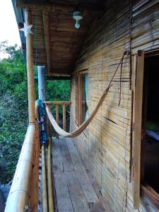 une terrasse couverte d'une maison en bois avec une corde dans l'établissement Refugio ecológico Villa Mercedes, à San Antonio del Tequendama