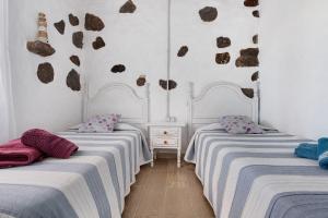 twee bedden in een kamer met witte muren bij Ca Lajares in Lajares