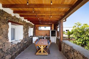 een patio met een tafel en een stenen muur bij Ca Lajares in Lajares