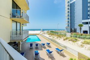 uma varanda com cadeiras e uma piscina e a praia em The Whaler 1A em Gulf Shores