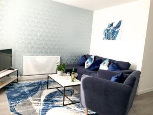 - un salon avec un canapé bleu et une table dans l'établissement De Montfort House, à Londres