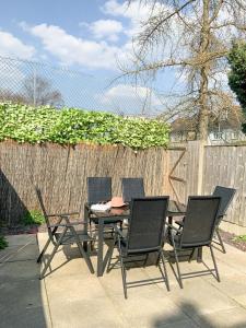 d'une terrasse avec une table, des chaises et une clôture. dans l'établissement De Montfort House, à Londres