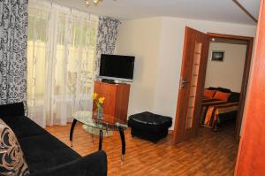 sala de estar con sofá y mesa con TV en Kristinos Apartamentai - Vytauto, en Palanga