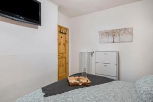 ein Schlafzimmer mit einem Bett und einem TV an der Wand in der Unterkunft Ciasa de Lucky in Moena