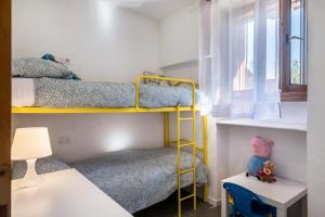 ein kleines Zimmer mit 2 Etagenbetten und einem Fenster in der Unterkunft Ciasa de Lucky in Moena