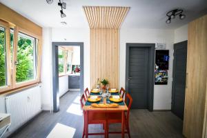 a dining room with a wooden table and chairs at Lynx in Pontarlier