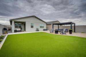 a backyard with a green lawn and a house at Buckeye Verrado Area Home with Pergola and Fire Pit in Litchfield Park