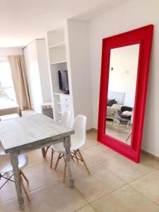 einen roten Spiegel im Wohnzimmer mit einem Tisch und Stühlen in der Unterkunft Dptos amoblados NQN - Excelente ubicacion- ZONA CENTRO in Neuquén