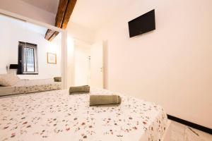 sypialnia z łóżkiem i telewizorem na ścianie w obiekcie Appartamento La Città Vecchia w Genui