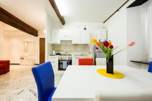 a kitchen with a white table with a vase of flowers on it at Appartamento La Città Vecchia in Genova