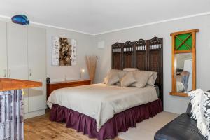 a bedroom with a large bed and a mirror at 39 North - Tutukaka Holiday Home in Tutukaka