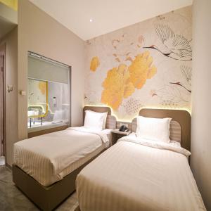 Duas camas num quarto com um mural de parede em Yulia Hotel Managed by HIG em Gorontalo