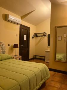 1 dormitorio con cama y espejo grande en B&B MontAlbano, en Caserta