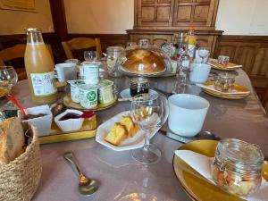 a table topped with plates of food and wine glasses at LA MAISON D'EULALIE in La Chapelle-du-Bard