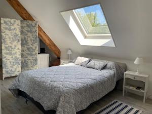 a bedroom with a bed with a large window at LA MAISON D'EULALIE in La Chapelle-du-Bard