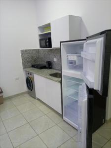 a kitchen with an open refrigerator and a sink at Jasmine rasort in Sharm El Sheikh
