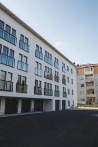 un grand bâtiment blanc avec beaucoup de fenêtres dans l'établissement Nordic Quality Apartments- Feel the North, à Rovaniemi 4 autres photos