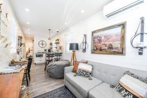 a living room with a gray couch and a kitchen at New Luxury Shipping Container in Bellmead
