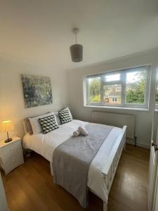 a bedroom with a large bed and a window at Charming 5-Bed House in Grays in Grays Thurrock