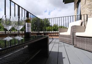 - Uma garrafa de vinho e 2 copos de vinho na varanda; em Stunning Acton Apartment With Balcony em Londres