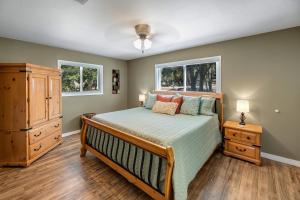 a bedroom with a bed and a dresser and two windows at BoGi in Canyon Lake