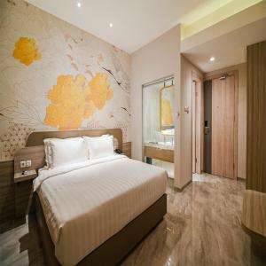 哥伦打洛省Yulia Hotel Managed by HIG的一间带大床的卧室和一间浴室