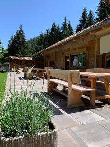 un patio con panchine e tavolo di fronte a un edificio di Unterurban DIE ZWEI a Senale-San Felice