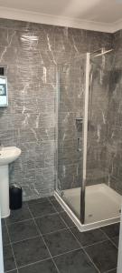 a shower with a glass door in a bathroom at Nikoda Lodge in Gillingham