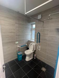 een kleine badkamer met een toilet en een raam bij Nikoda Lodge in Gillingham