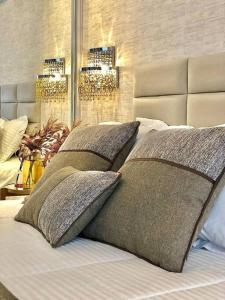 Una cama con cuatro almohadas encima. en Gramado Centro ao lado das compras e Rua Coberta Vita, en Gramado