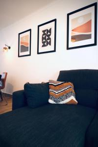 un sofá azul en una sala de estar con fotos en la pared en Vilamoura 2 Bedroom with Pool - Na Casa De Pascal, en Vilamoura