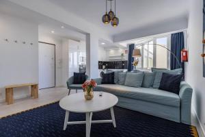 uma sala de estar com um sofá azul e uma mesa em Urban Elegance Apartment em Almada