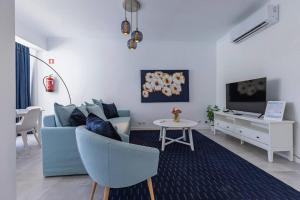 a living room with a blue couch and a table at Urban Elegance Apartment in Almada