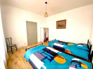 een slaapkamer met een blauw bed in een kamer bij Demeure St Martin in Vierzon