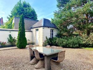 a glass table and chairs in a yard at Demeure St Martin in Vierzon