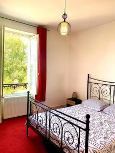 sypialnia z dużym łóżkiem i oknem w obiekcie Demeure St Martin w mieście Vierzon