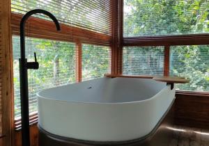 a large white bath tub in a room with windows at Numa Experimental in Pontevedra