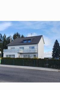 een groot wit huis aan de kant van een straat bij 100 qm DG Wohnung 《Kehr wieder》Bexbach Saarland in Bexbach