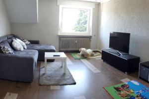 een woonkamer met een bank en een hond op de vloer bij 100 qm DG Wohnung 《Kehr wieder》Bexbach Saarland in Bexbach